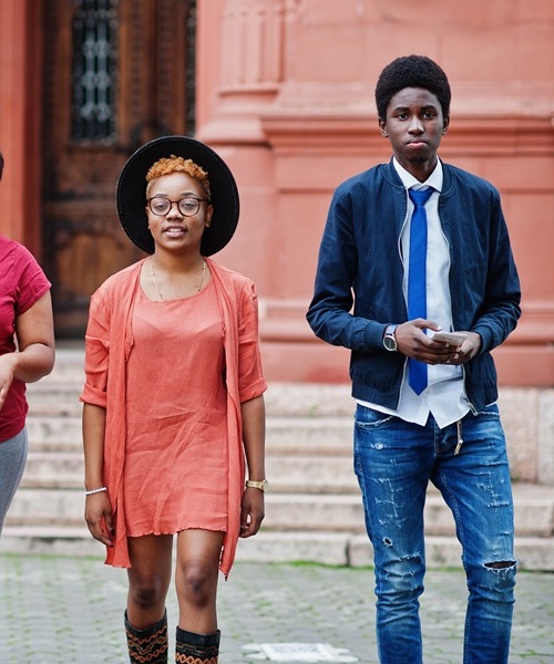 Four african friends having fun outdoors. Two black girls with g