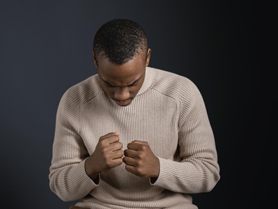portrait-man-sitting-with-clenched-fists